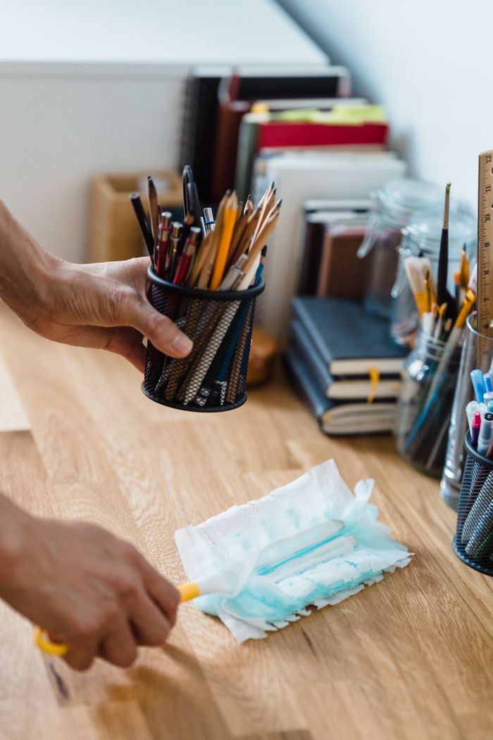 Un bureau propre et ordonné avec de la papeterie et des produits de dépoussiérage pour un espace de travail efficace.